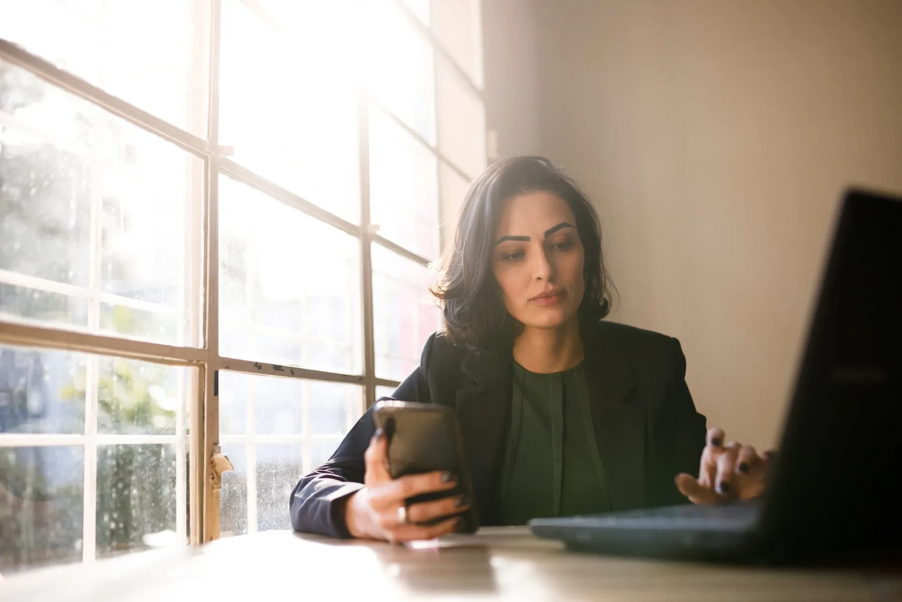 A woman sits at a desk working on bookkeeping tasks